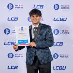 This photo depicts a student with their award against the LCBU photo wall.