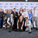 This photo depicts a student with their award against the LCBU photo wall.