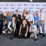 This photo depicts a student with their award against the LCBU photo wall.