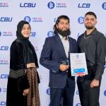 This photo depicts a student with their award against the LCBU photo wall.