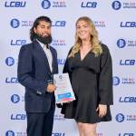 This photo depicts a student with their award against the LCBU photo wall.