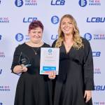 This photo depicts a student with their award against the LCBU photo wall.
