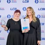 This photo depicts a student with their award against the LCBU photo wall.