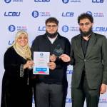 This photo depicts a student with their award against the LCBU photo wall.