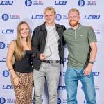 This photo depicts a student with their award against the LCBU photo wall.