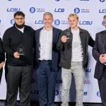 This photo depicts two students with their awards against the LCBU photo wall.