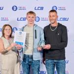 This photo depicts a student with their award against the LCBU photo wall.
