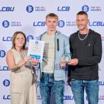 This photo depicts a student with their award against the LCBU photo wall.