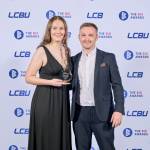 This photo depicts a student with their award against the LCBU photo wall.