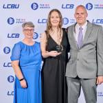 This photo depicts a student with their award against the LCBU photo wall.