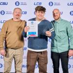 This photo depicts a student with their award against the LCBU photo wall.