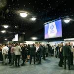 This photo depicts guests socialising as well as one of the events large digital presentation screens.