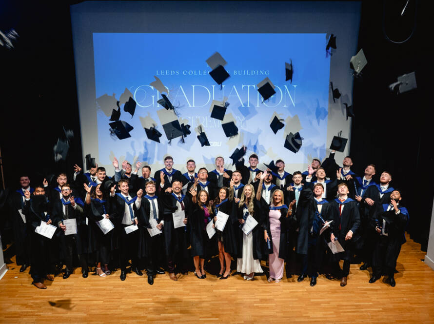 LCBU Graduates tossing their caps in the air.